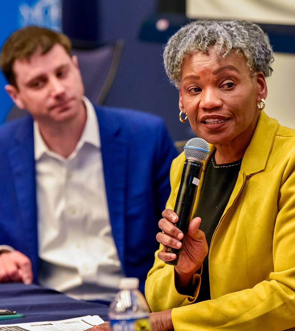 Close up of professional talking at a microphone during a panel discussion