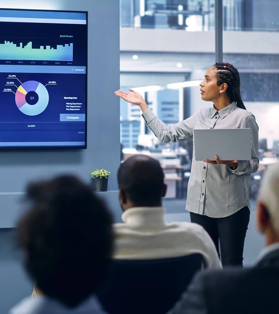Researcher presenting data on big screen to audience in an office setting